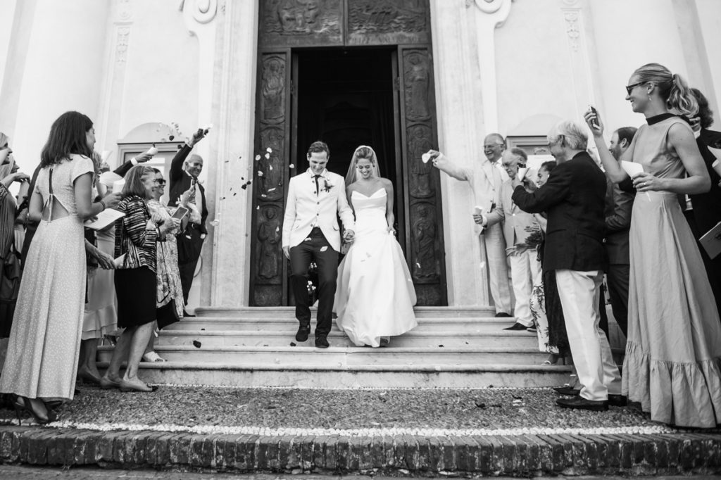 sposi scendono le scale della chiesa wedding photographer in santa maria ligure genoa lancio dei petali