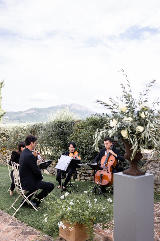 musicians play violins in the garden during the cerimony in one of the most beautiful venue in Umbria