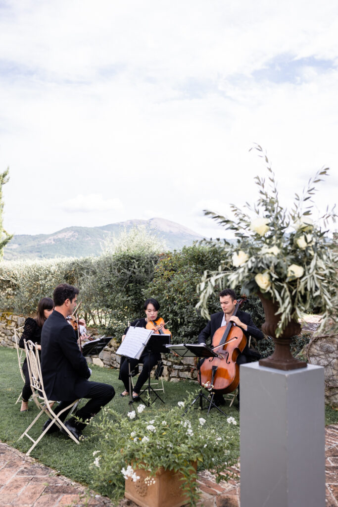 musicians play violins in the garden during the cerimony in one of the most beautiful venue in Umbria