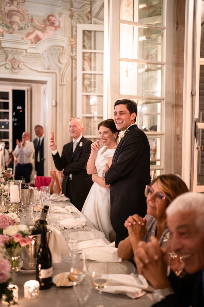 bride and groom during the dinner in a beautiful villa in portofino, smiling for the speeches