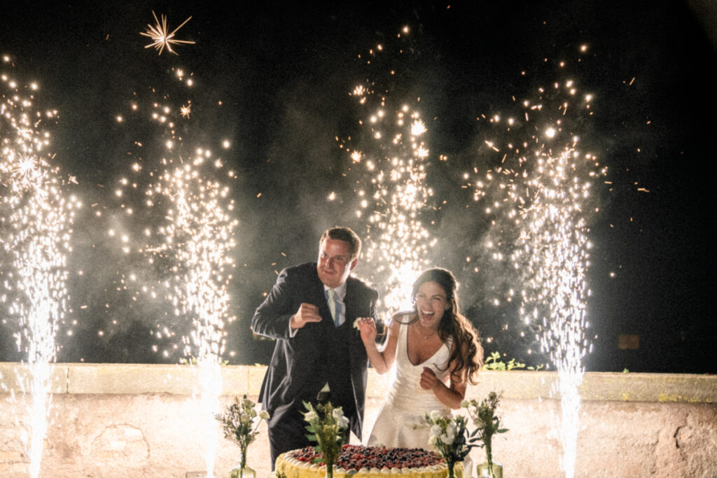 bride and groom cake moment with fireworks